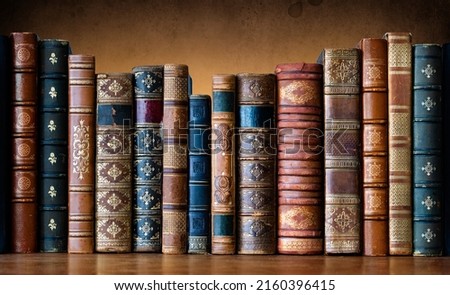 Old books on wooden shelf. Tiled Bookshelf background.  Concept on the theme of history, nostalgia, old age. Retro style. The book is a symbol of knowledge.