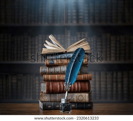 Old books ,quill pen and vintage inkwell on wooden desk in old library. Ancient books historical background. Retro style. Conceptual background on history, education, literature topics.
