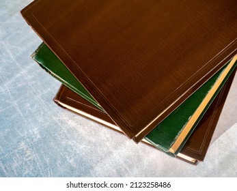 Old books are stacked on the table. Books are shifted relative to each other. View from above. Close-up. The concept of education, scientific work.