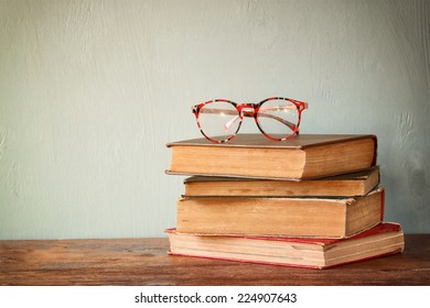 Old books with vintage glasses on a wooden table. retro filtered image  - Powered by Shutterstock