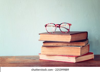 Old books with vintage glasses on a wooden table. retro filtered image  - Powered by Shutterstock