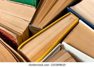 Old books with yellow pages bound together by colorful covers. Abstrack background