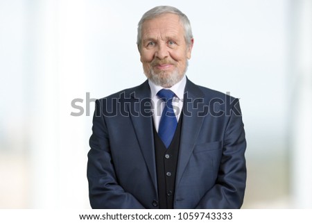 Old boss in suit portrait. Bright blurred background.