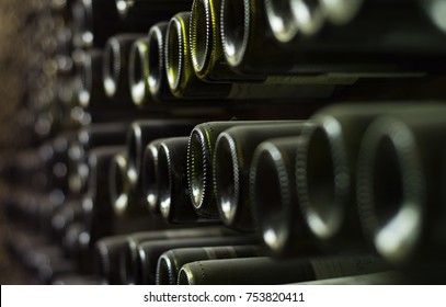 old bottle of wine on the wall of cellar in close-up view