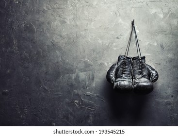 old boxing gloves hang on nail on texture wall with copy space for text. Retirement concept - Shutterstock ID 193545215