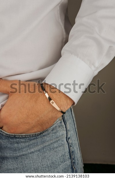 old bracelet in a man's hand, men's jewelry, a man
in a white shirt