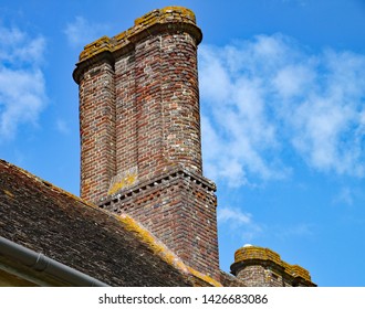 An old brick chimney stack atop an old English house