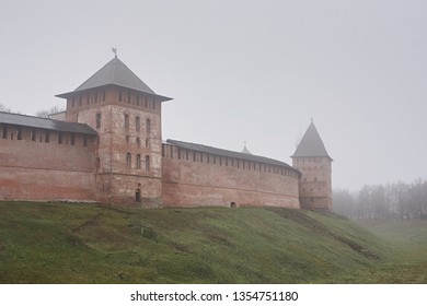 Old brick fortress in the towers in Veliky Novgorod on the background of a foggy sky in autumn - Shutterstock ID 1354751180