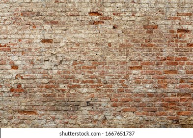 Old brick wall. Brickwork from an old brick in a rustic style. The structure and pattern of the destroyed stone wall. Copy space.