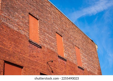Old brick wall with brick filled windows. Red brick wall a factory with four bricked up windows with space for text. House brick wall. Street photo, nobody