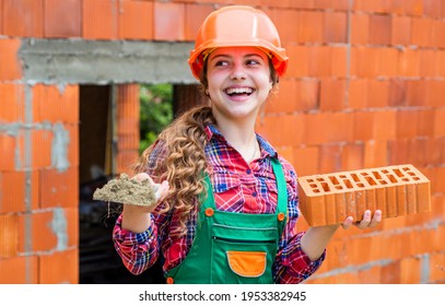 Old Brick Wall Repair. Kid Wear Helmet On Construction Site. Teen Girl Builder With Building Brick. Bricklayer Child On Repairing Work. Concept Of Renovation In Workshop. Busy Professional Carpenter