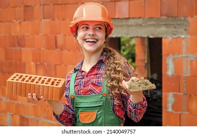 Old Brick Wall Repair. Kid Wear Helmet On Construction Site. Teen Girl Builder With Building Brick. Bricklayer Child On Repairing Work. Concept Of Renovation In Workshop. Busy Professional Carpenter