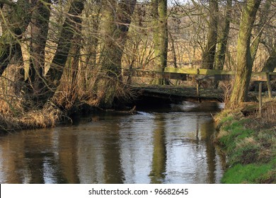 Old Bridge Over A Small River In Winter