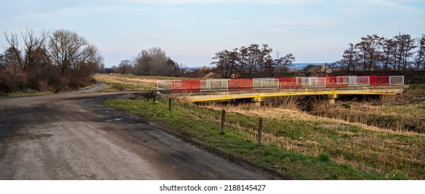 Old Bridge Over Stream With Red And White Railings.