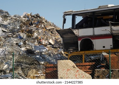 Old Broken Bus With Metal Trash Mountain Background, Clear Sky And Sunny Day