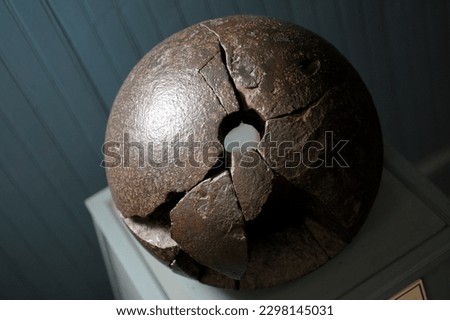 An old broken cannon ball on display