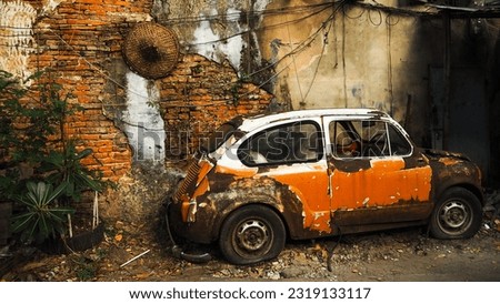 An old broken car parking at old brick wall