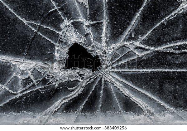 Old broken glass car window as background image,\
black and white image