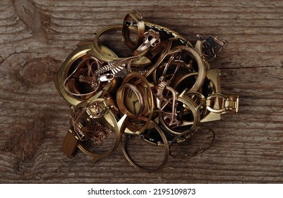 Old And Broken Jewelry, Coins, Watches Of Gold And Gold-plated 
On A Wooden Background.