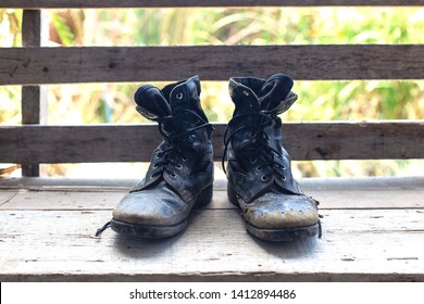 Old And Broken Jungle Shoes  Placed On The Old Wooden Floor