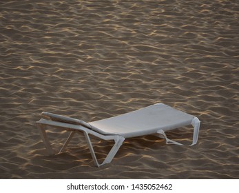 Old Broken Lounger Chair On The Beach During Sunset. Copy Space.