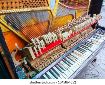 An Old Broken Piano With A Missing Wall And Broken Keys