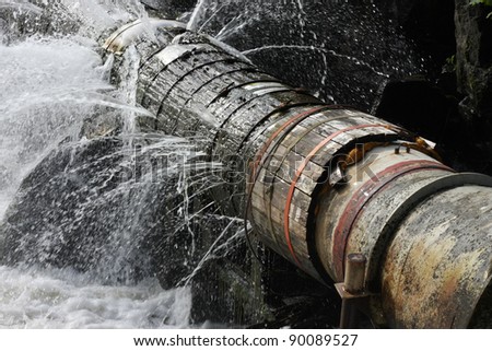 An old broken pipe that leaks water in all directions.