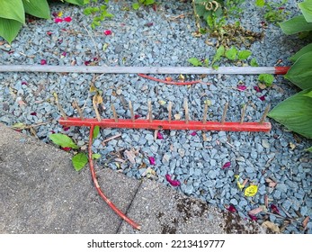 An Old And Broken Rake Sitting On Some Crushed Rock.