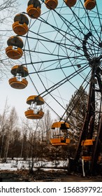 Old Broken Rotten Radioactive Ferris Wheel With Yellow Parts Abandoned Among Vegetation And Dirt In The City Of Pripyat, The Chernobyl Disaster, Ukraine, Kyiv Region