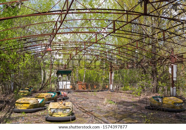 Old broken rusty metal\
radioactive children\'s electric cars  abandoned, the park of\
culture and recreation in the city of Pripyat, the Chernobyl\
disaster, Ukraine.