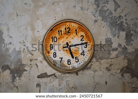 Old broken rusty wall clock in an abandoned building in Pripyat, Chornobyl Exclusion zone, Ukraine. Time flows concept.