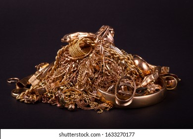 Old and broken scrap gold metal jewellery on black background