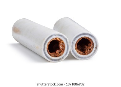 Old broken sludge plumbing polypropylene pipes with red rust and limescale. Corrosion, sludge and hard water concept. Obsolete pipes isolated on white background