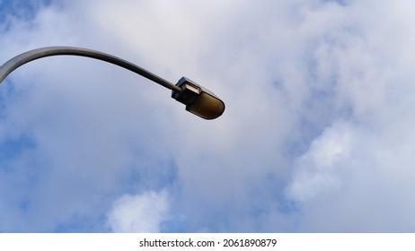 An Old And Broken Street Lamp Under A Bright Blue Sky