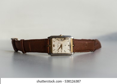 Old broken wrist watch. Damaged glass clock