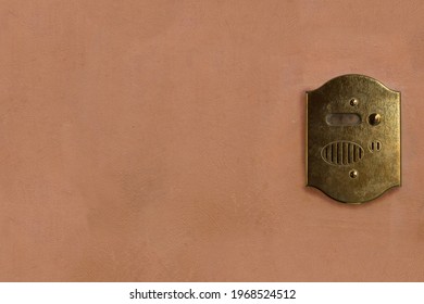 Old bronze intercom on painted wall. Vintage background, mock up.