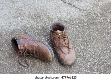 Old Brown Leather Shoes On The Floor. Pair Of Old Dirty Brown Leather Shoes.