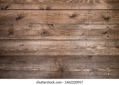 Old brown wood background made of dark natural wood in grunge style. The view from the top. Natural raw planed texture of coniferous pine. The surface of the table to shoot flat lay. Copy space
