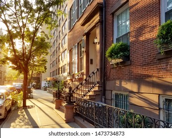 Old brownstone buildings along a quiet neighborhood street in Greenwich Village, New York City NYC