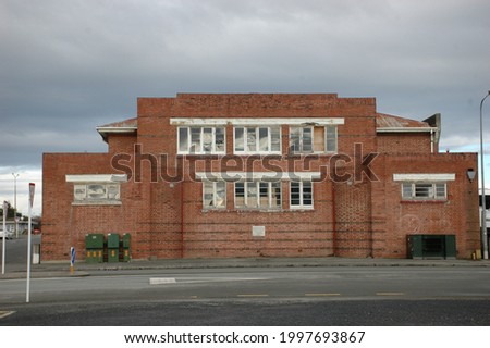 old building abandoned rundown roadside urban road street sign glass windows brick factory sky grey brown dump lonely scary