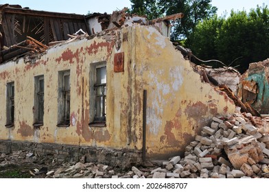 Old building. A dilapidated white brick building with a broken wooden roof.