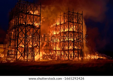 Old building in full flaming inferno on dark background