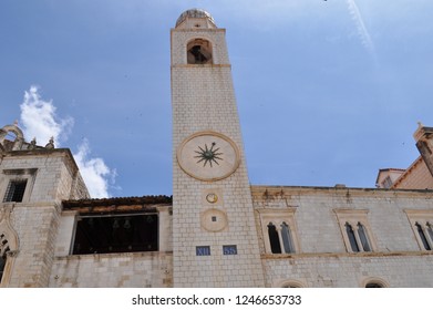Old building with tower and interesting clock on it. 