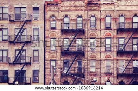 Old buildings with fire escapes, one of the New York City symbols, color toned picture, USA.