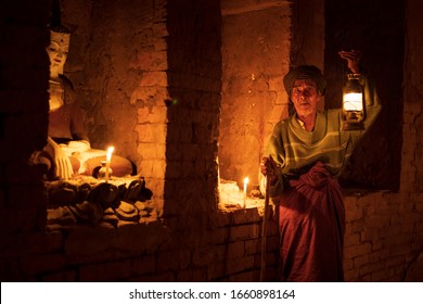 Old Burmese Man Holding Lantern In A Stupa