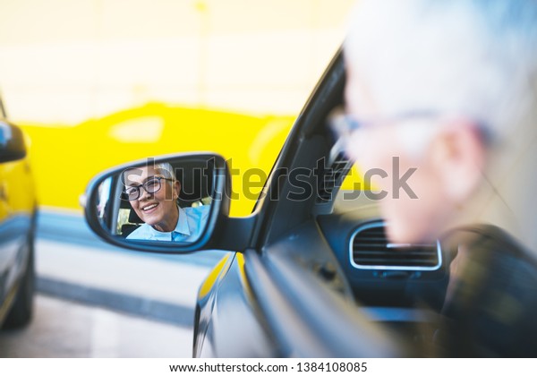 Old business woman\
sitting in the car
