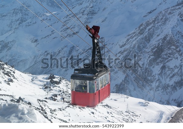 Old cable car\
transports people on a background of mountains and snow in the ski\
resort, Mount Elbrus, Azau