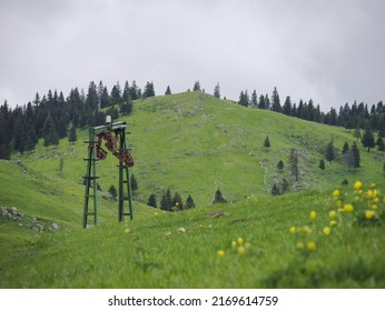 Old cableway on a green hill with the grey sky in the background, Velika Planina, Slovenia