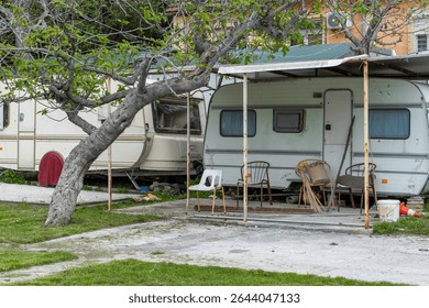 Old Camper Trailers Under Tree in Backyard