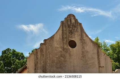 An Old Cape Dutch Gable With Dirt Against A Blue Sky